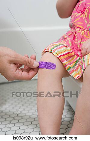 Adult putting plaster on girl View Large Photo Image Stock Photograph - Adult putting plaster on girl. Fotosearch
