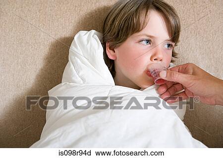Stock Image - Boy being given medicine. Fotosearch