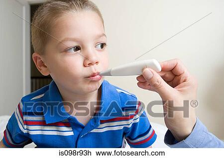 Stock Image - Boy having his temperature taken. Fotosearch