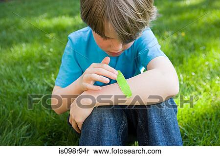 Boy putting plaster on arm View Large Photo Image Stock Photography - Boy putting plaster on arm. Fotosearch