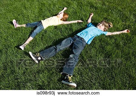 Children lying on grass View Large Photo Image Stock Image - Children lying on grass. Fotosearch