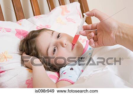 Girl being given medicine View Large Photo Image Stock Photo - Girl being given medicine. Fotosearch