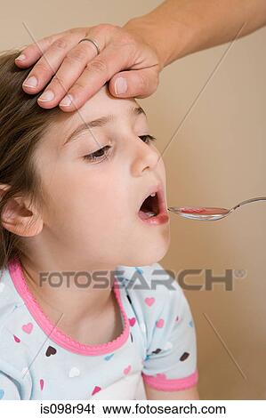 Girl being given medicine View Large Photo Image Stock Photograph - Girl being given medicine. Fotosearch