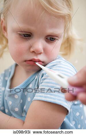 Stock Image - Girl having her temperature taken. Fotosearch