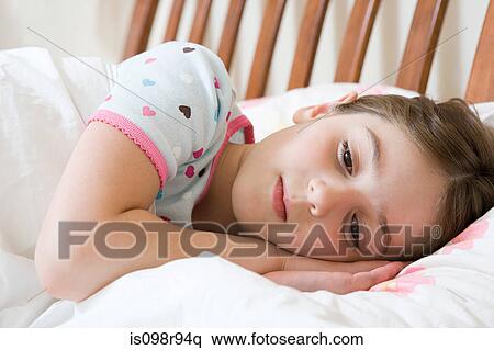 Girl lying in bed View Large Photo Image Stock Photography - Girl lying in bed. Fotosearch