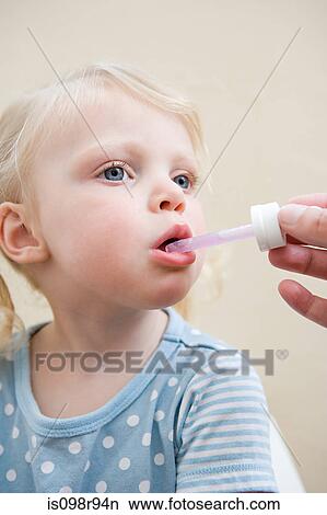 Little girl being given medicine View Large Photo Image Picture - Little girl being given medicine. Fotosearch