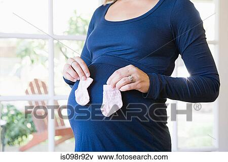 Pregnant woman with baby socks View Large Photo Image Stock Photo - Pregnant woman with baby socks. Fotosearch