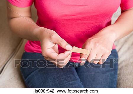 Woman putting plaster on finger View Large Photo Image Stock Image - Woman putting plaster on finger. Fotosearch