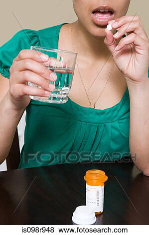 Woman taking tablets View Large Photo Image Stock Photo - Woman taking tablets. Fotosearch