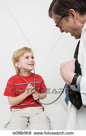 Boy and doctor with stethoscope View Large Photo Image Stock Photo - Boy and doctor with stethoscope. Fotosearch