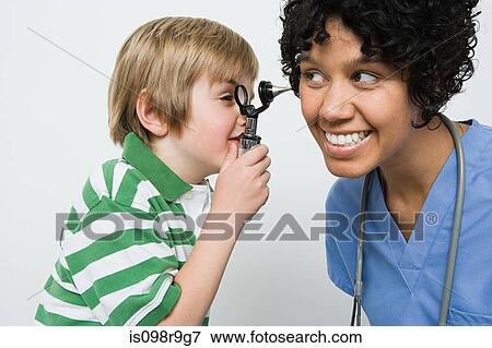 Boy looking in nurses ear View Large Photo Image Stock Photo - Boy looking in nurses ear. Fotosearch