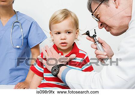 Stock Photo - Doctor looking in boys ear. Fotosearch