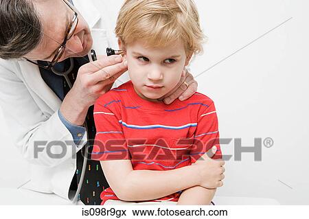 Stock Photo - Doctor looking in boys ear. Fotosearch