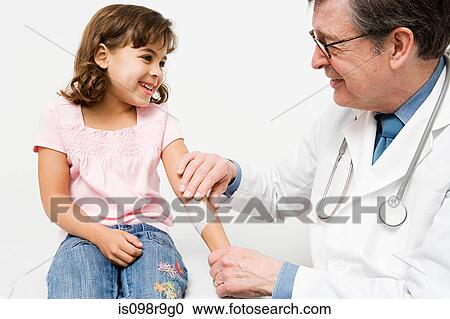 Doctor putting plaster on girl View Large Photo Image Stock Image - Doctor putting plaster on girl. Fotosearch