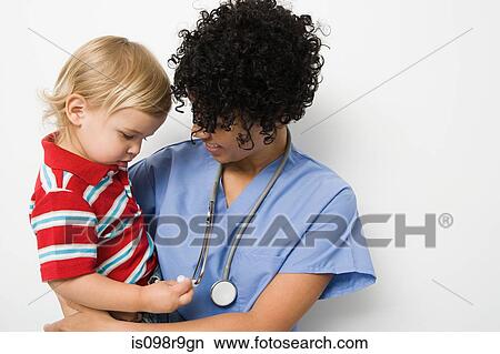 Nurse holding toddler View Large Photo Image Picture - Nurse holding toddler. Fotosearch