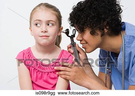 Nurse looking in girls ear View Large Photo Image Stock Image - Nurse looking in girls ear. Fotosearch