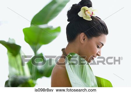 Young woman holding a large leaf View Large Photo Image Stock Photo - Young woman holding a large leaf. Fotosearch