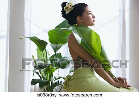 Young woman holding a large leaf View Large Photo Image Stock Photo - Young woman holding a large leaf. Fotosearch