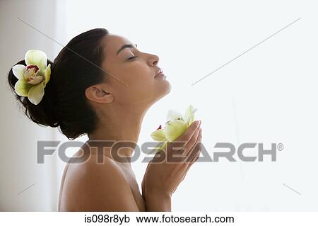 Young woman holding an orchid flower View Large Photo Image Stock Image - Young woman holding an orchid flower. Fotosearch