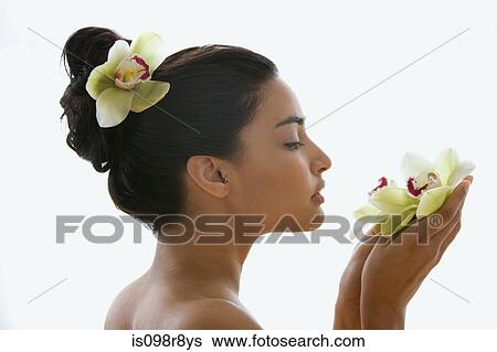 Young woman holding an orchid flower View Large Photo Image Stock Photograph - Young woman holding an orchid flower. Fotosearch
