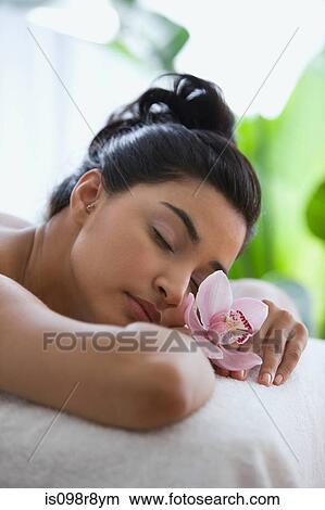 Young woman on massage table with orchid flowers View Large Photo Image Picture - Young woman on massage table with orchid flowers. Fotosearch