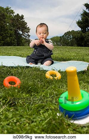 Baby boy in park with toy rings View Large Photo Image Stock Image - Baby boy in park with toy rings. Fotosearch