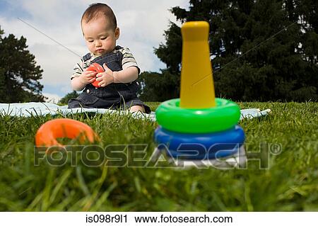 Baby boy in park with toy rings View Large Photo Image Stock Image - Baby boy in park with toy rings. Fotosearch