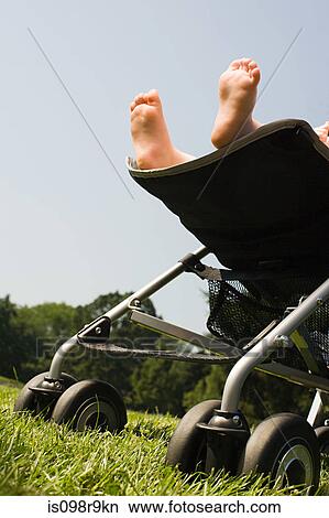 Picture - Feet of baby in push chair. Fotosearch