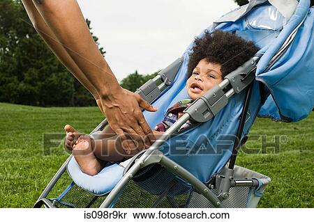 Parent reaching for baby in push chair View Large Photo Image Stock Photography - Parent reaching for baby in push chair. Fotosearch