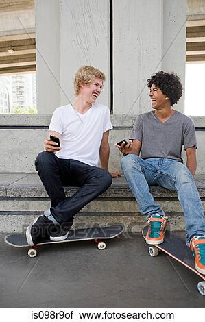 Teenage boys with cellphones and skateboards View Large Photo Image Stock Image - Teenage boys with cellphones and skateboards. Fotosearch