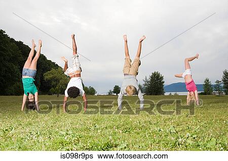 Stock Photograph - Teenagers doing handstands. Fotosearch
