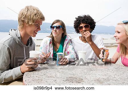 Teenagers having drinks and snacks View Large Photo Image Picture - Teenagers having drinks and snacks. Fotosearch
