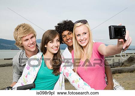 Stock Image - Teenagers using digital camera. Fotosearch