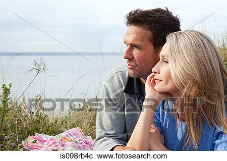 Couple outdoors looking towards sea View Large Photo Image Stock Image - Couple outdoors looking towards sea. Fotosearch
