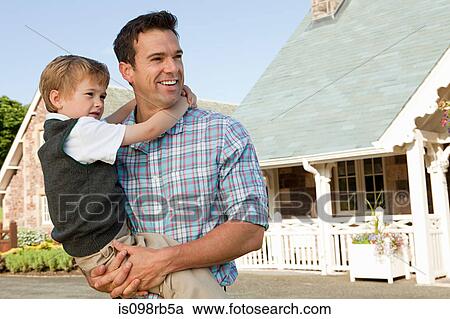 Stock Image - Father and son by holiday home. Fotosearch