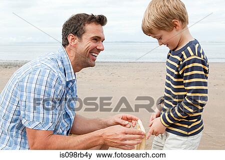 Father and son on beach with cricket stumps View Large Photo Image Stock Photo - Father and son on beach with cricket stumps. Fotosearch