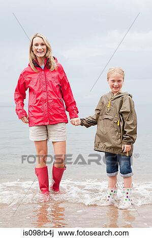 Mother and daughter standing in the sea View Large Photo Image Stock Image - Mother and daughter standing in the sea. Fotosearch