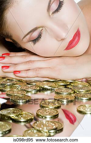 Stock Photography - Coins and woman woman with eyes closed. Fotosearch