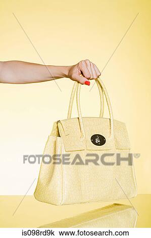Woman holding yellow handbag View Large Photo Image Stock Image - Woman holding yellow handbag. Fotosearch