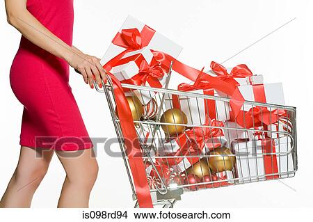 Woman with shopping trolley full of christmas gifts View Large Photo Image Picture - Woman with shopping trolley full of christmas gifts. Fotosearch
