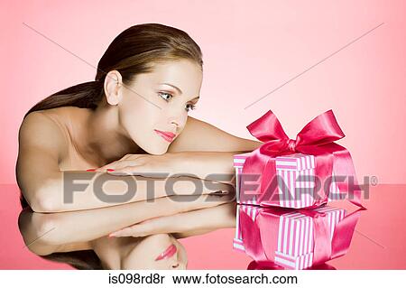 Stock Photography - Young woman looking at gift. Fotosearch