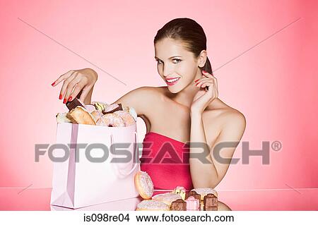 Picture - Young woman with bag of cakes and donuts. Fotosearch