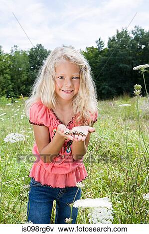 Girl holding a butterfly View Large Photo Image Stock Photo - Girl holding a butterfly. Fotosearch