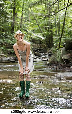 Stock Image - Woman standing in river. Fotosearch