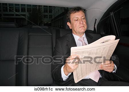 Businessman reading a newspaper in car View Large Photo Image Stock Image - Businessman reading a newspaper in car. Fotosearch