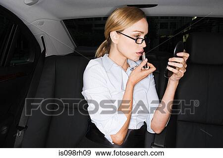 Businesswoman applying lipstick View Large Photo Image Stock Photo - Businesswoman applying lipstick. Fotosearch