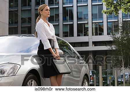 Businesswoman leaning on a car View Large Photo Image Stock Photography - Businesswoman leaning on a car. Fotosearch