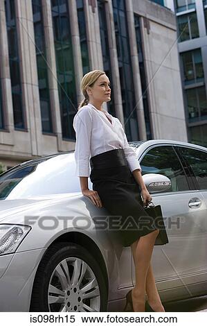 Stock Photography - Businesswoman leaning on a car. Fotosearch