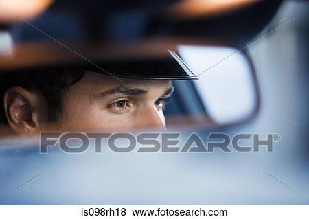 Chauffeur reflected in rear view mirror View Large Photo Image Stock Photo - Chauffeur reflected in rear view mirror. Fotosearch