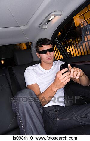 Cool man text messaging in car View Large Photo Image Stock Image - Cool man text messaging in car. Fotosearch